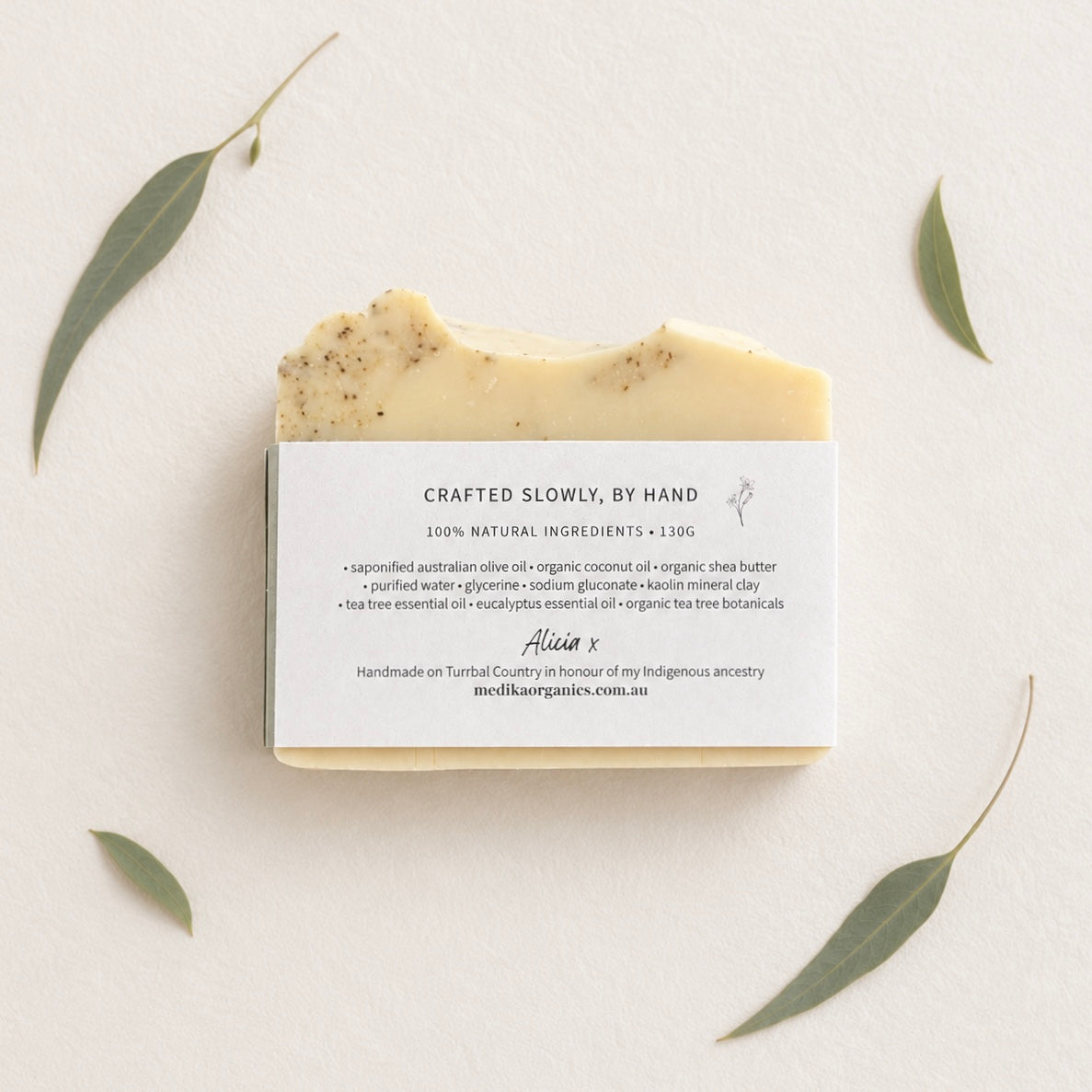 Natural handmade tea tree oil soap photographed with fresh eucalyptus botanicals. Ingredient list. Australian artisan cold process soap made with nourishing olive oil.