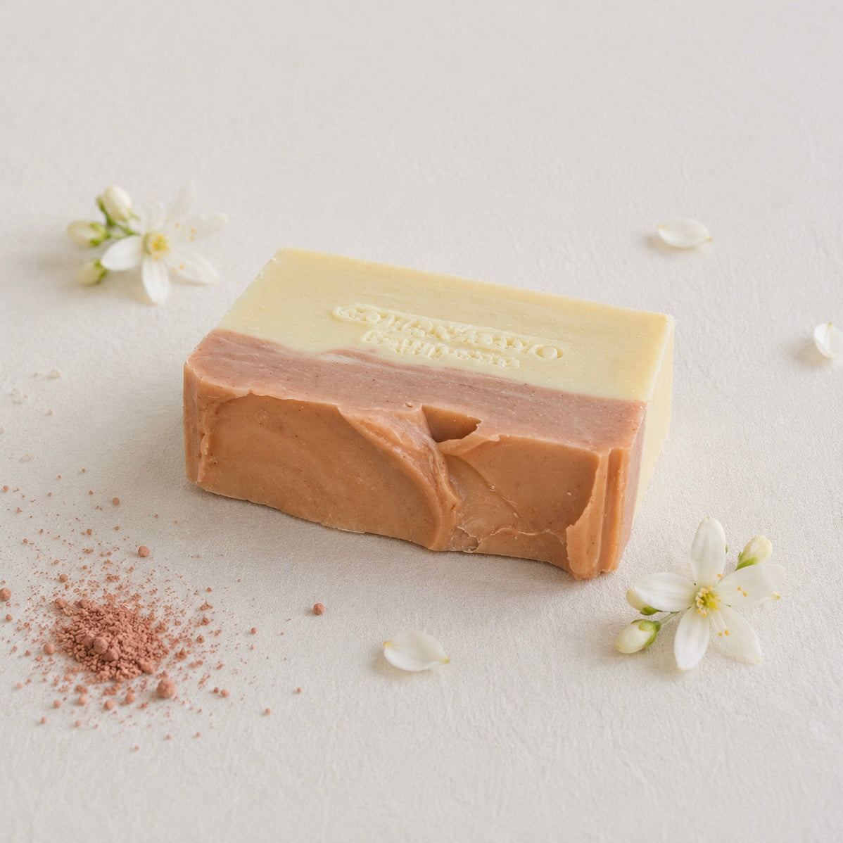 A rectangular bar of handmade soap with a two-tone design, featuring a cream half and a warm peachy-brown top half. The brand name 'Medika Organics' is embossed on the top.