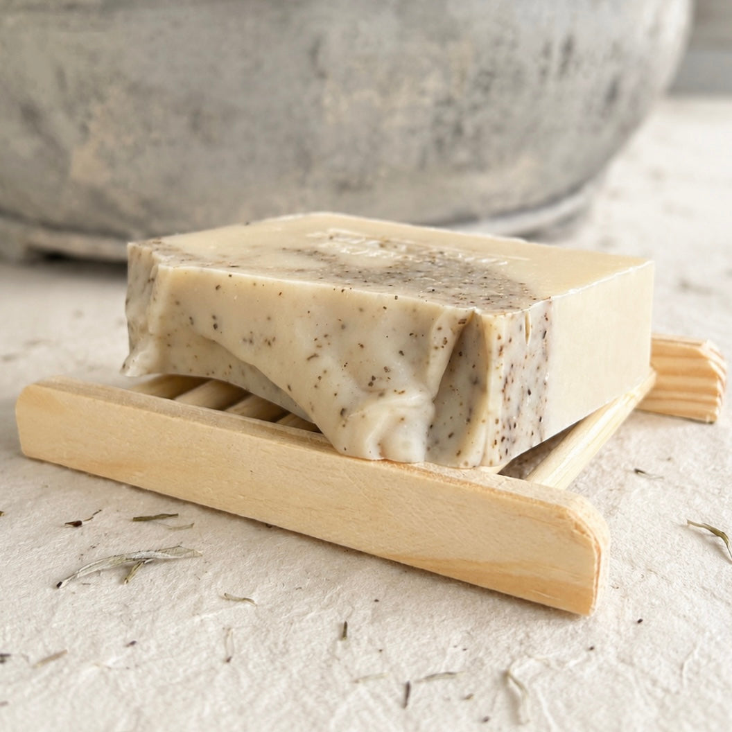 Natural handmade tea tree and eucalyptus soap resting on a wooden soap dish. Australian cold process soap with pure essential oils and a long-lasting bar.